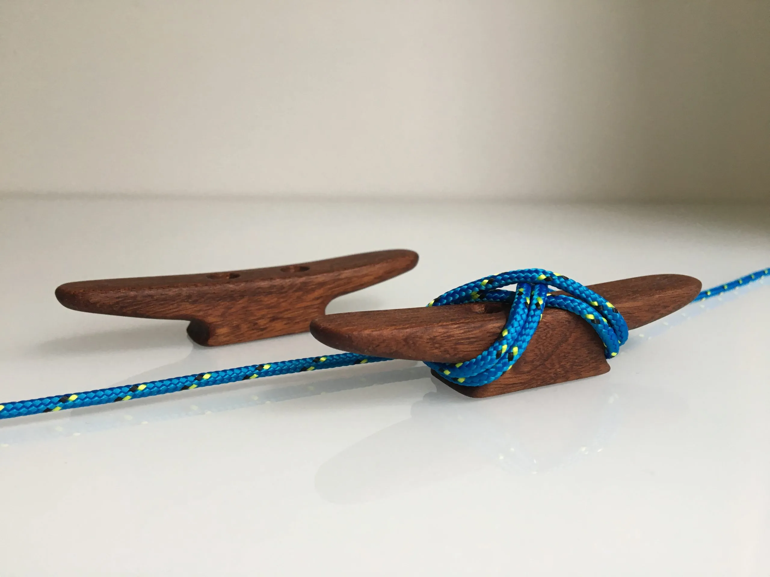 Thin rope tied in a figure eight around the horns of the mahogany cleat
