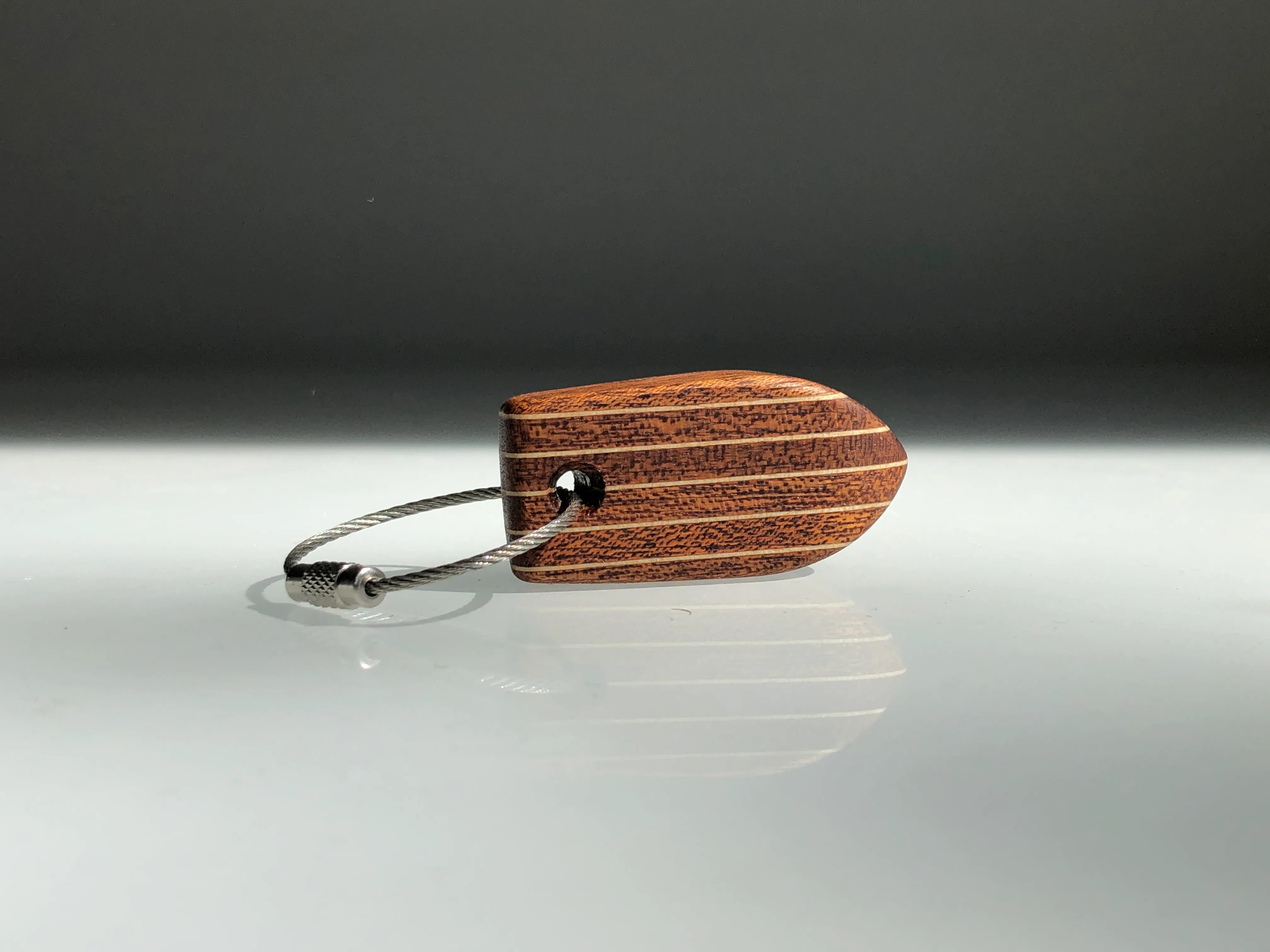 A teak and birch deck-style keychain on a stainless ring