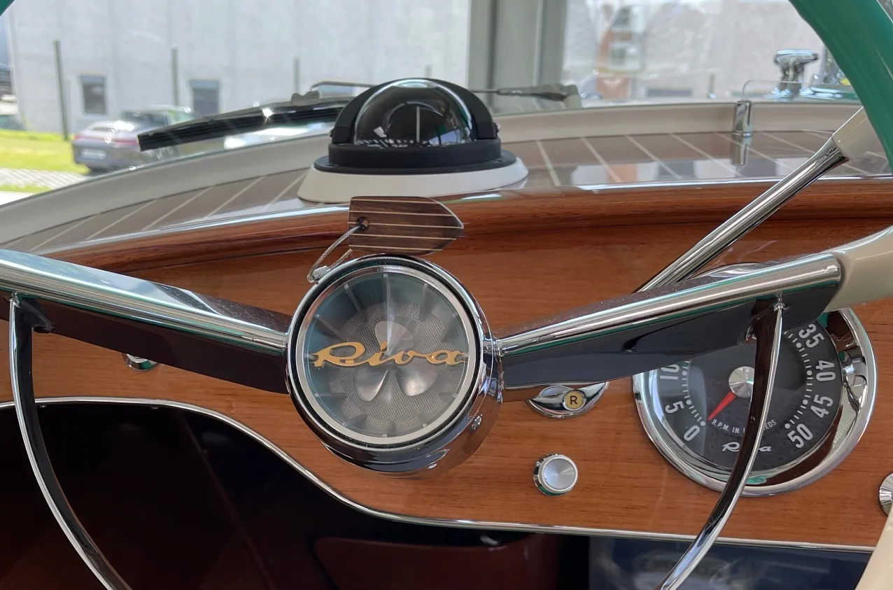 The varnished mahogany dashboard and compass of a classic Riva runabout