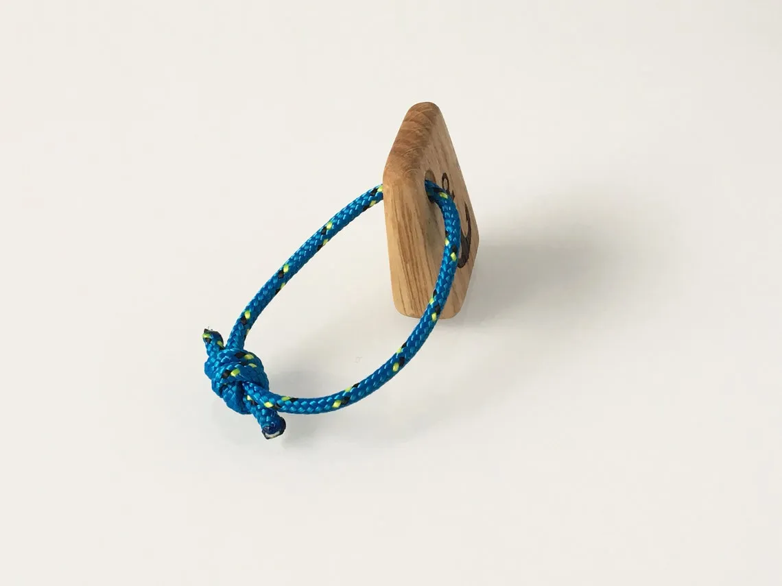 Anchor keyring hanging from a stainless steel loop against pale linen