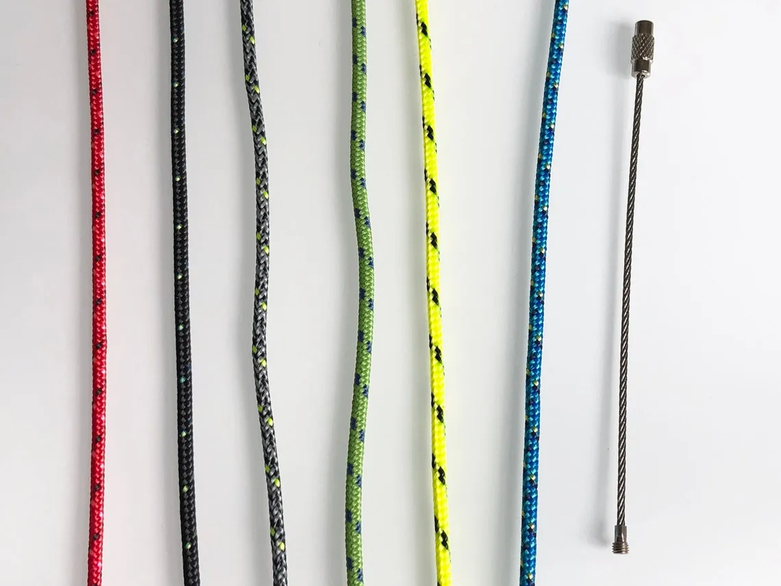 Keychain hanging against a plain wall with the rope loop above the wood