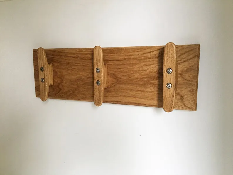 Coat rack in use with a jacket and a tote bag hung from the cleats