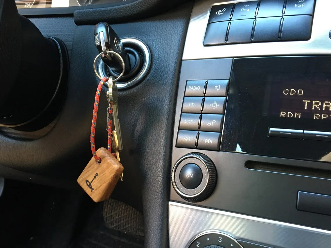 The keyring hanging from a bunch of keys beside a boat hatch