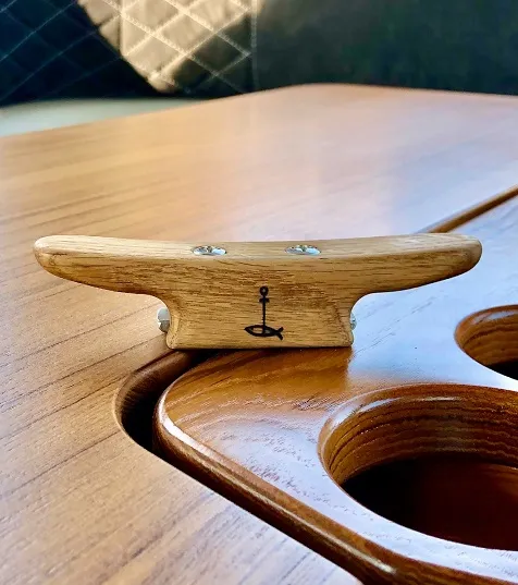 A wooden boat cleat fitted to the varnished deck of a classic motorboat