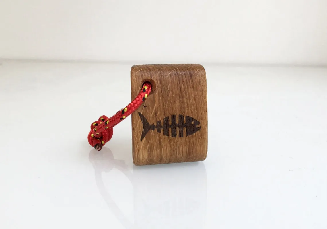 Oak keychain burned with a fish bone motif on a workbench