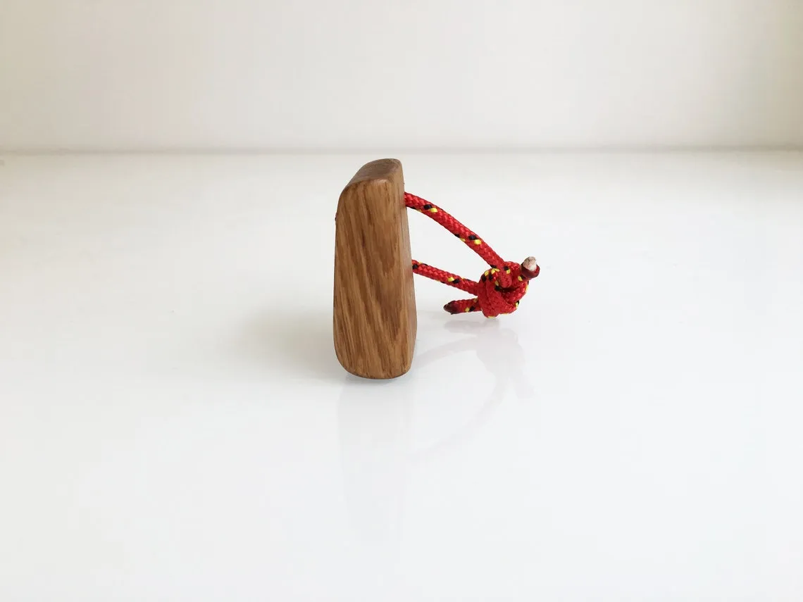 Red yacht rope knotted through the hole in the oak block