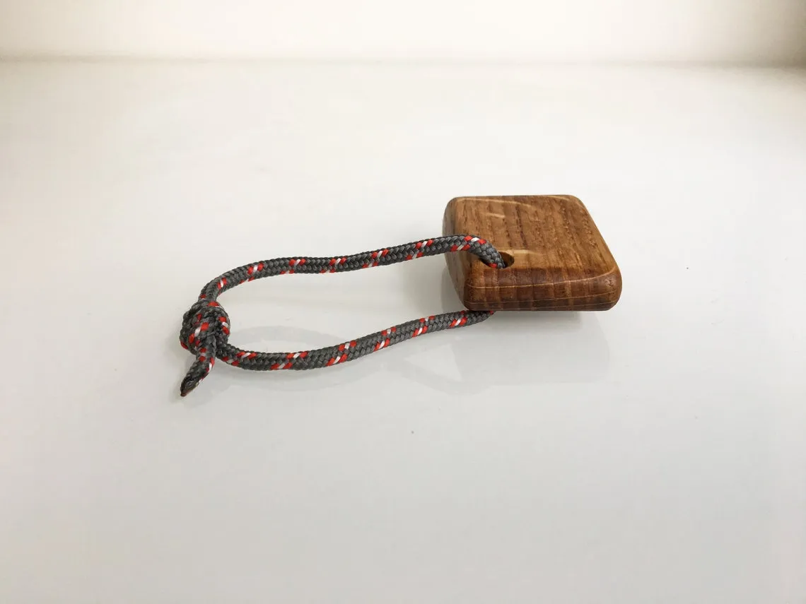 Red rope tuna keychain laid out on pale linen cloth