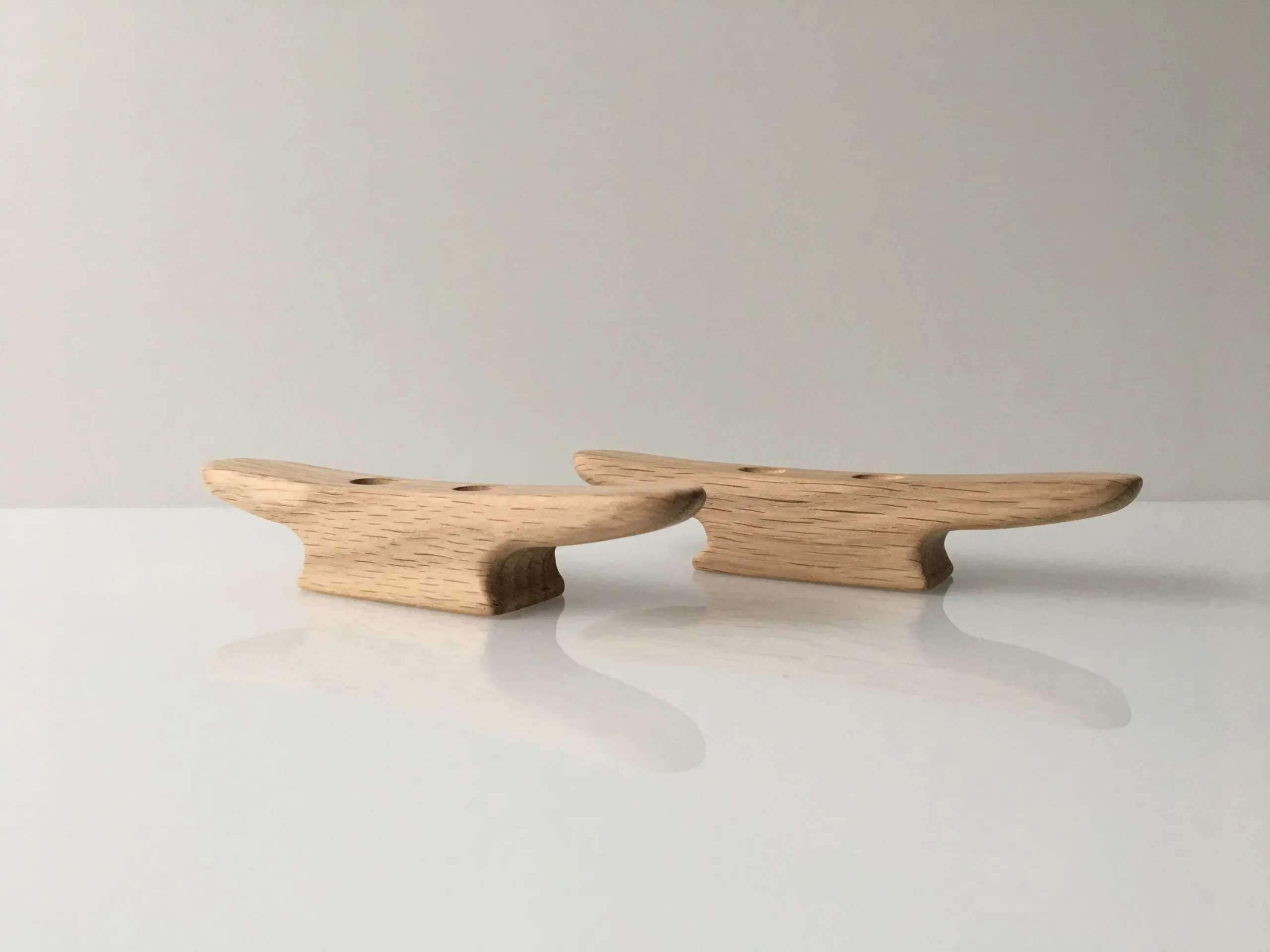 Untreated oak boat cleats in pale natural wood, laid side by side