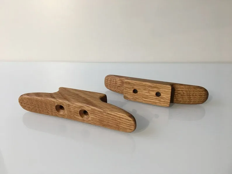 One cleat from the pair held in a hand for scale