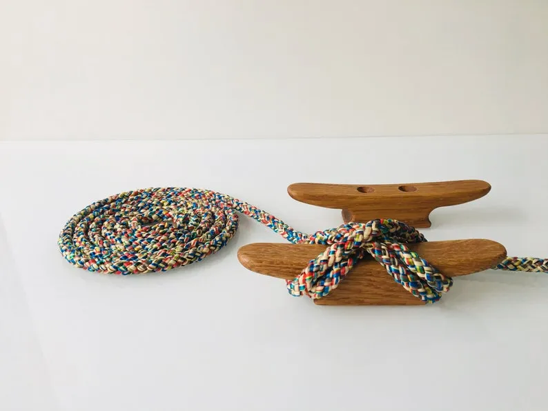 Oak cleat mounted on a dock rail with a mooring line led through