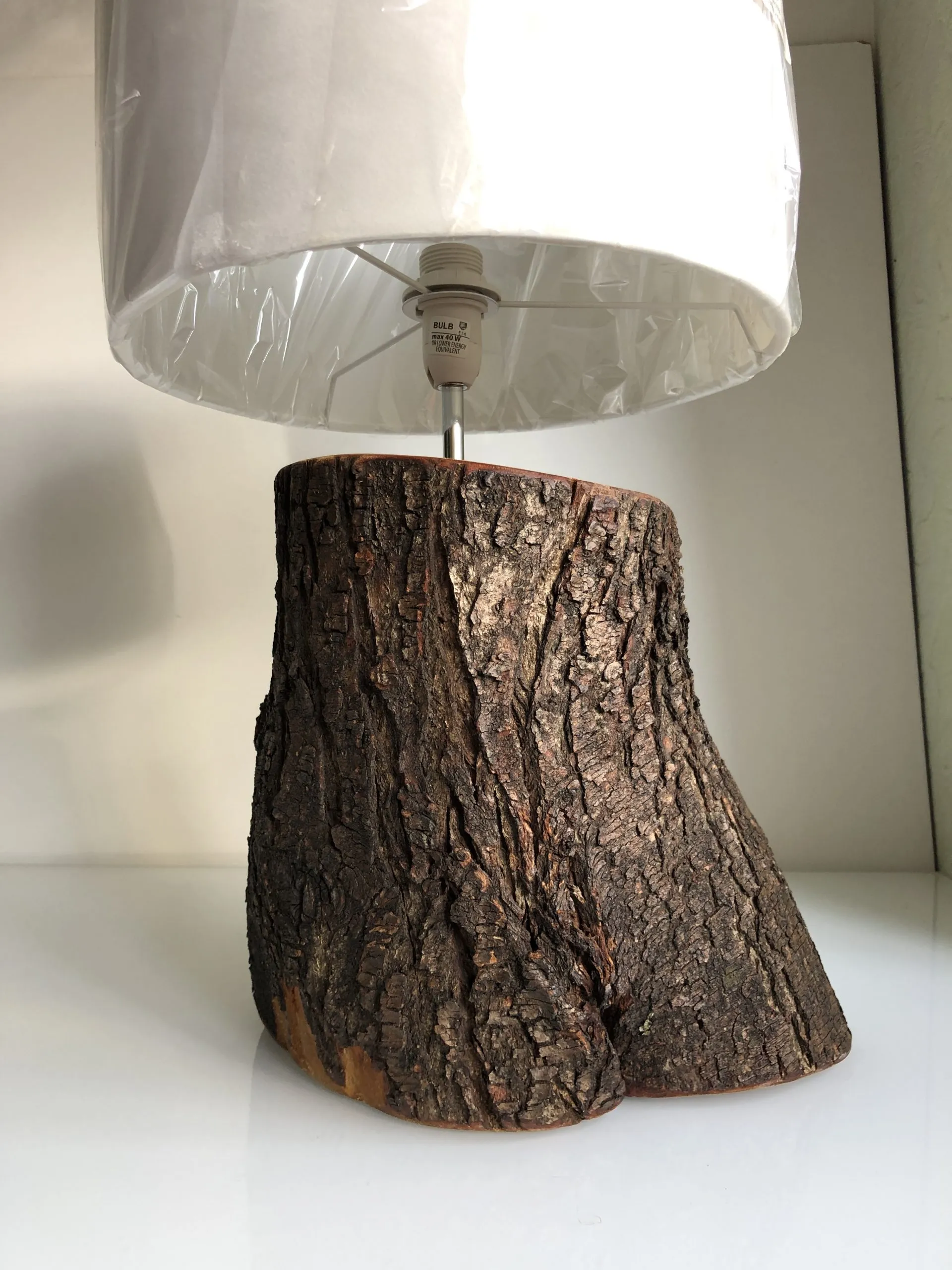 A lamp built into a bark-covered log section, shade lit from within