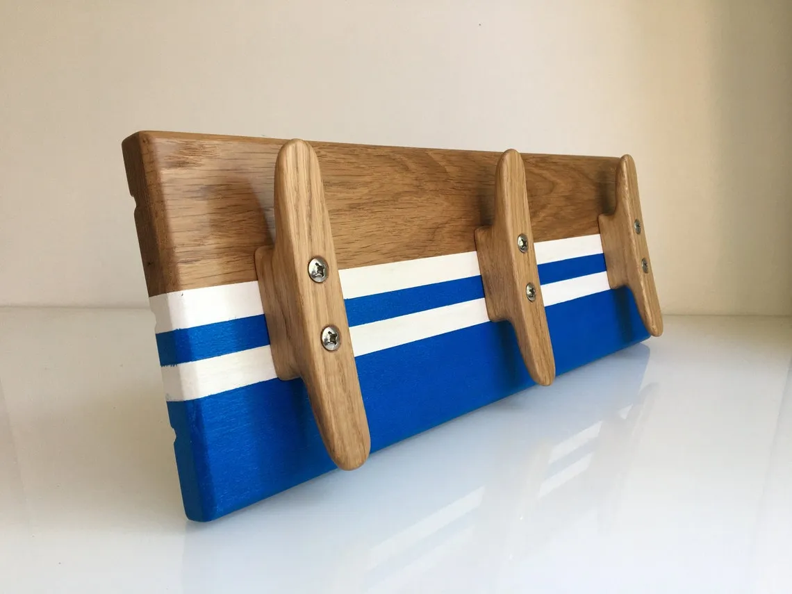 Oak boat cleat coat rack mounted on a white wall, three cleats in a row