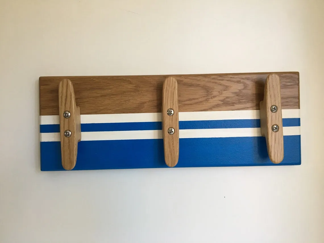 Coat rack by the door holding a jacket and a canvas bag