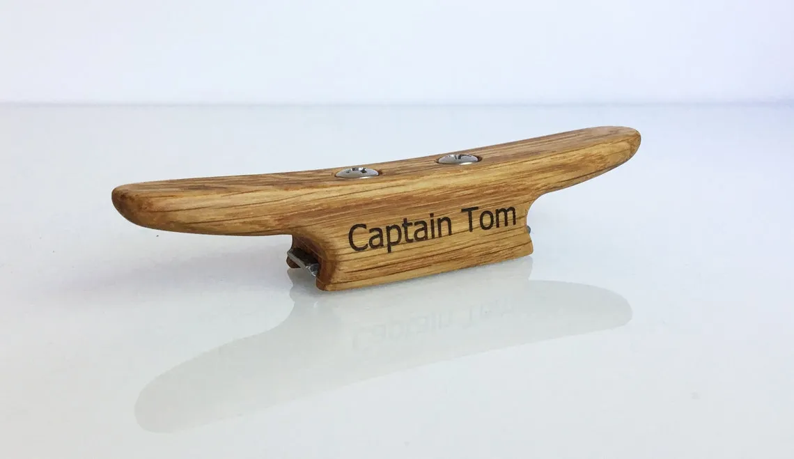 Oak boat cleat bottle opener resting on a varnished table top