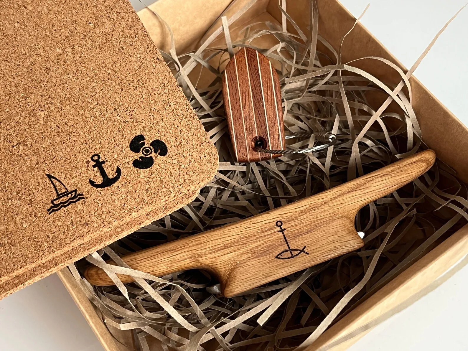 Open gift box with bottle opener, mahogany keychain and two cork coasters