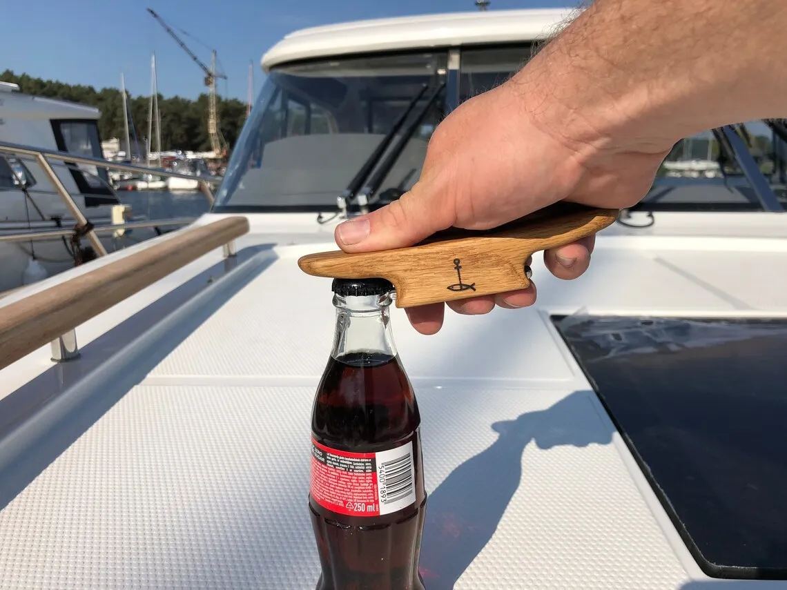 Hand gripping the opener while lifting a bottle cap