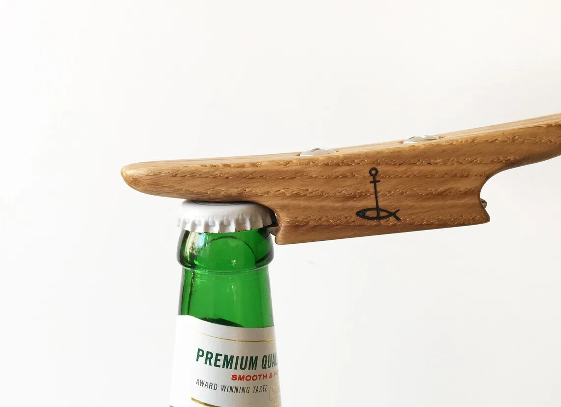 The opener lying across a varnished table beside a beer bottle