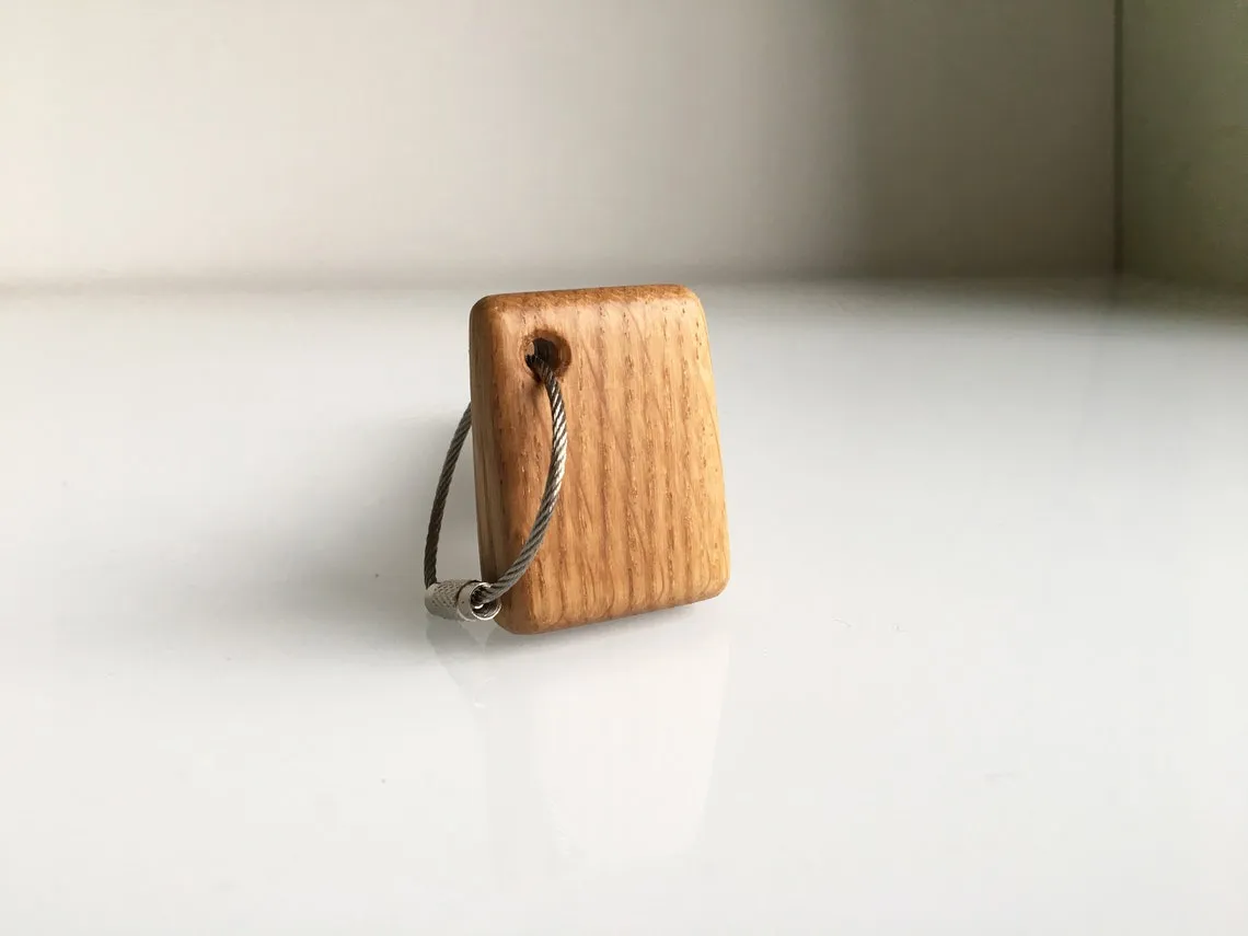 Keychain hanging from a set of house keys in a hand