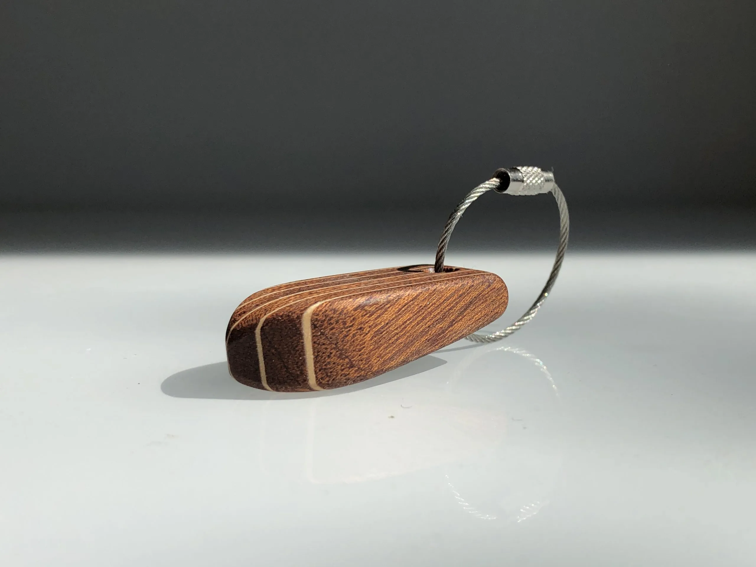 Keychain resting in a palm, stainless steel loop hanging down