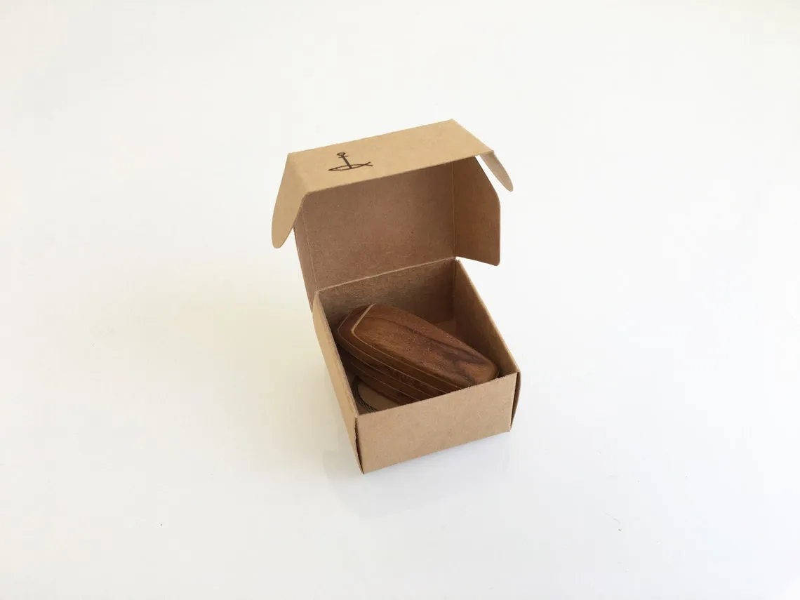 Edge view showing the layered teak and birch build of the keychain