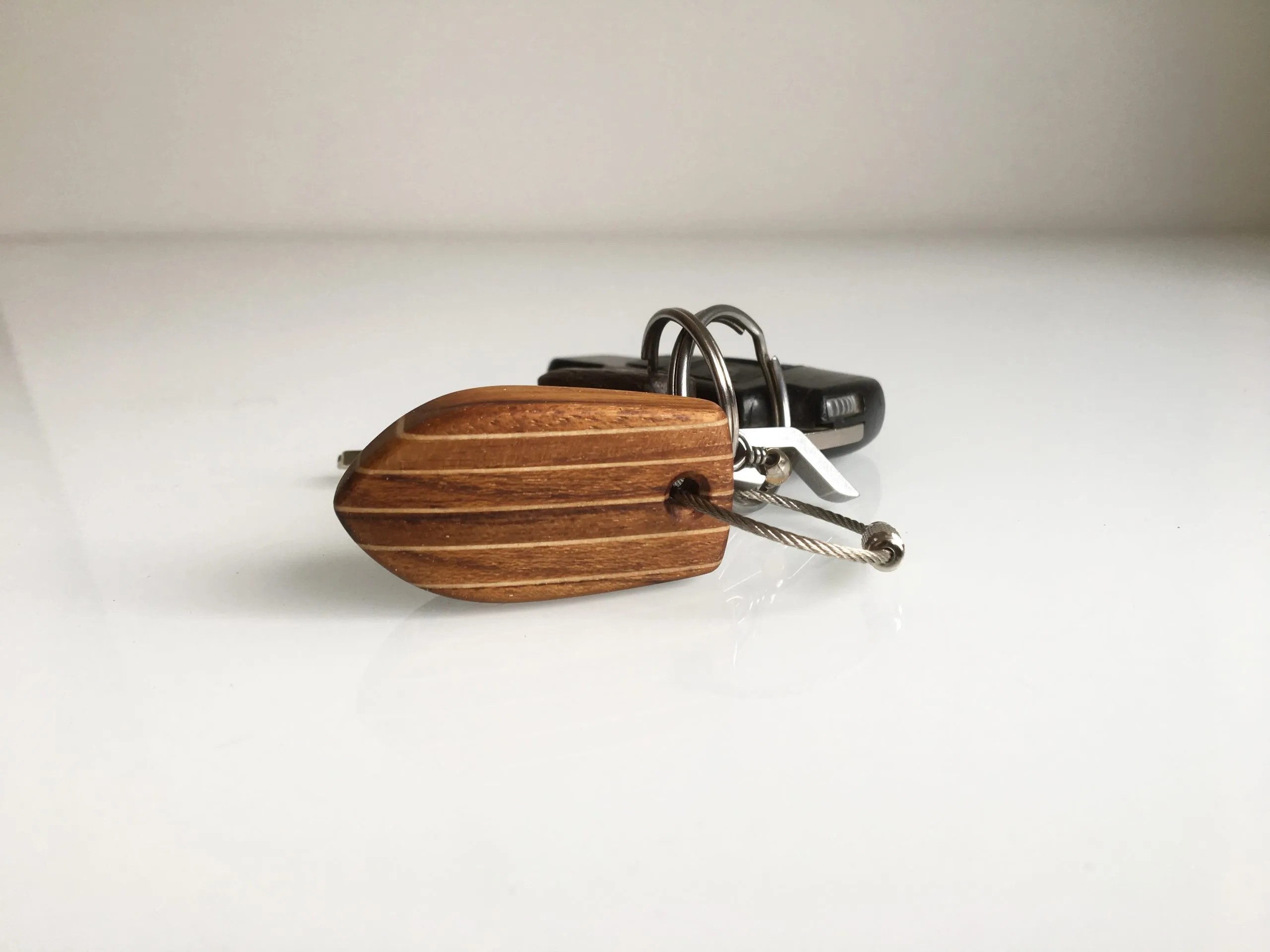 Keychain next to a set of keys on a wooden table