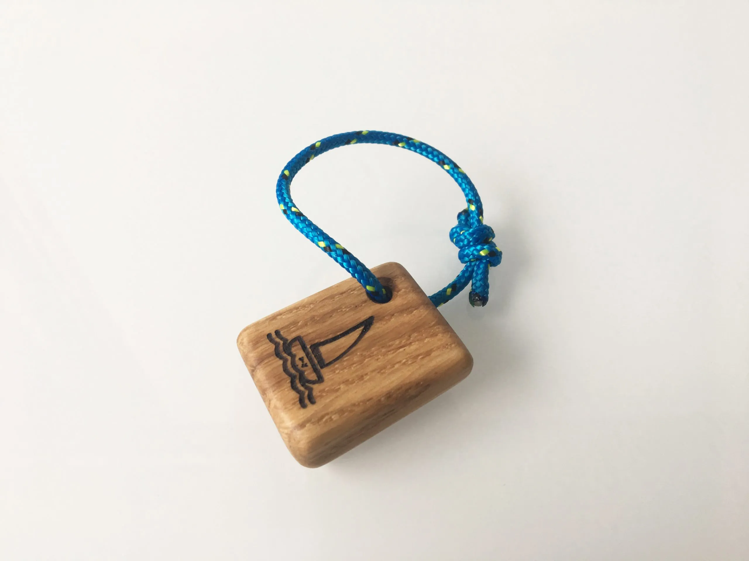Angled view showing the rounded edges and oak grain of the keychain