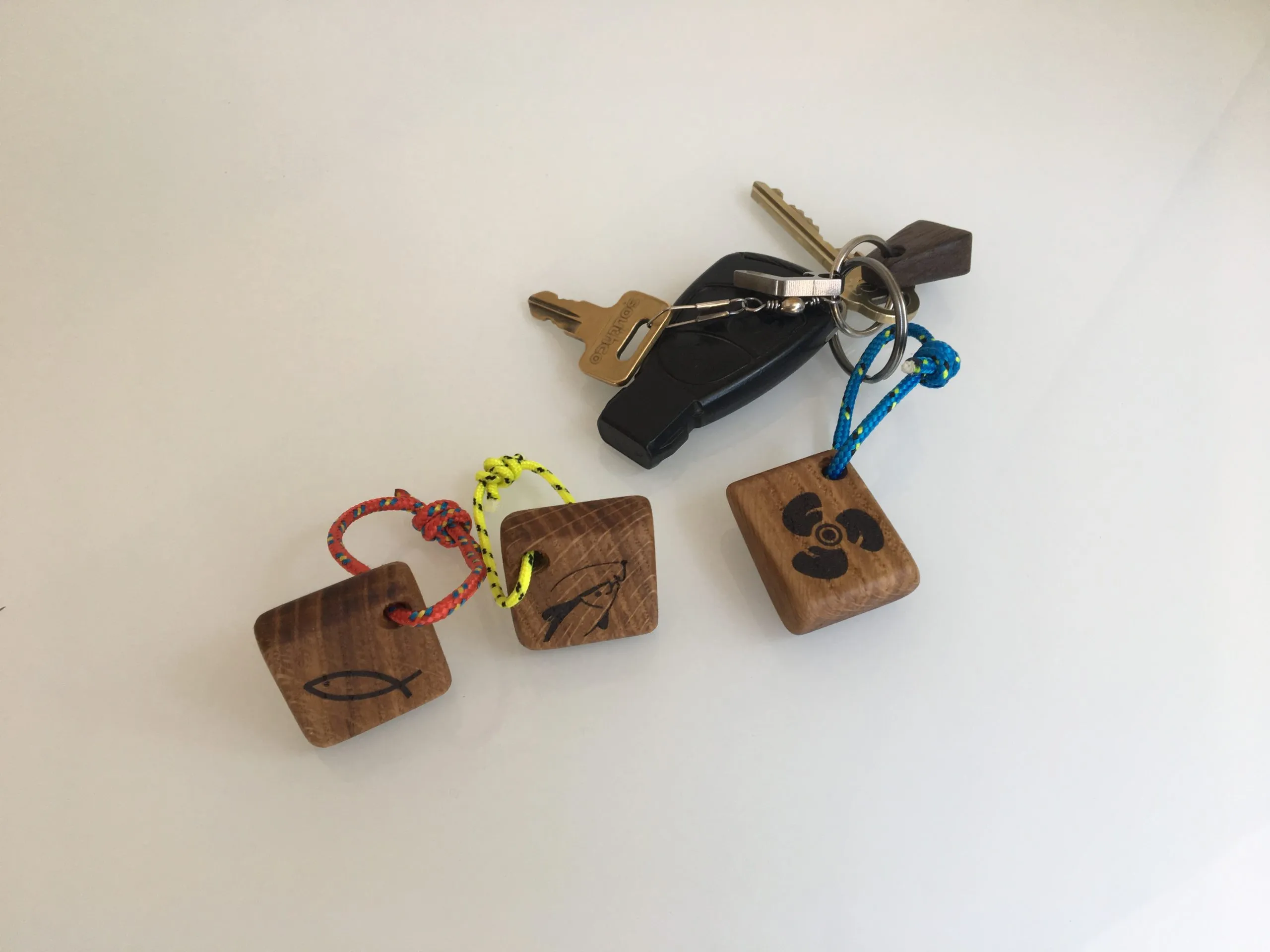 Several sailboat keychains with blue, yellow and green yacht rope
