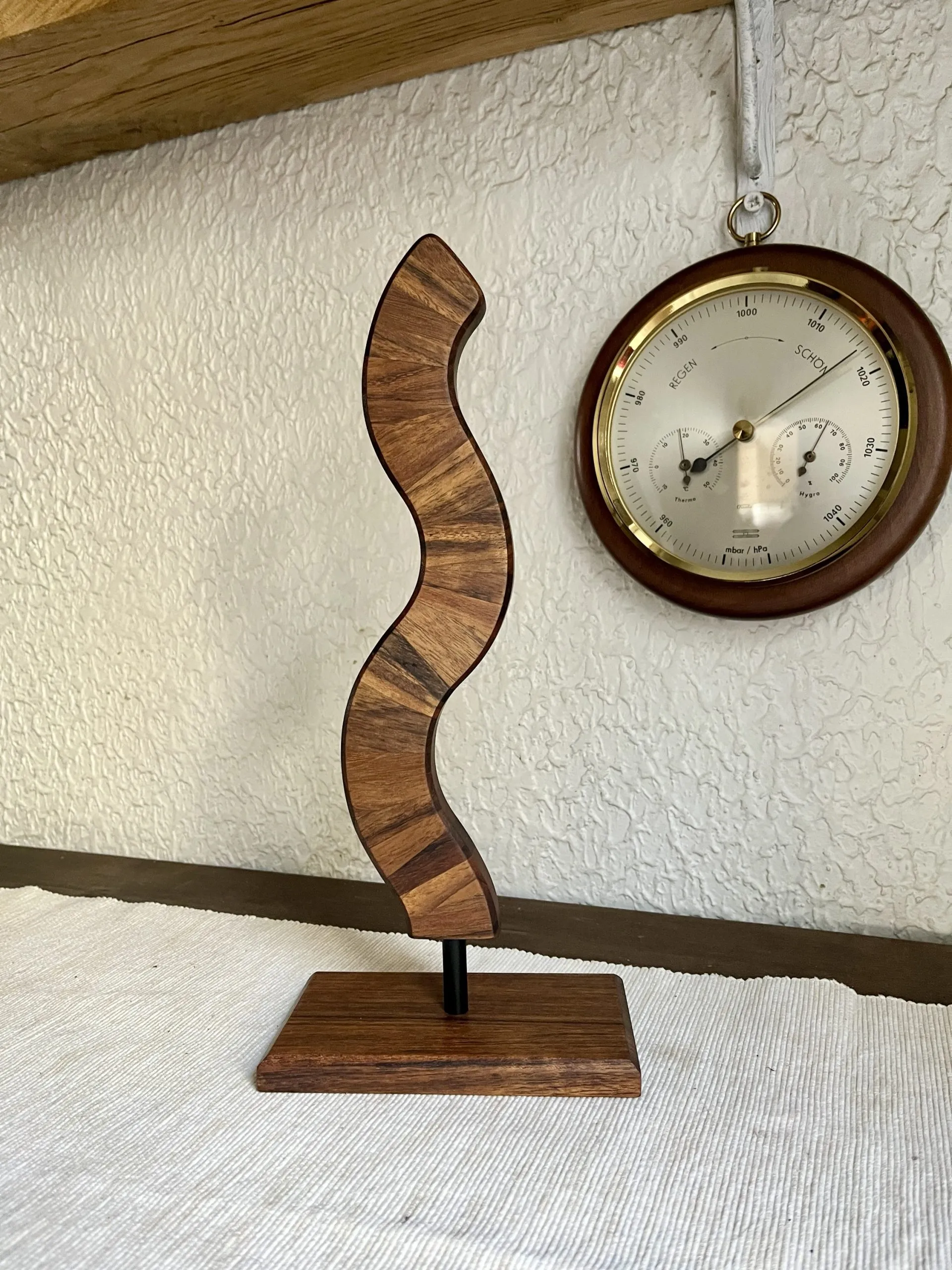 Warm teak tones of the sculpture set against a dark background
