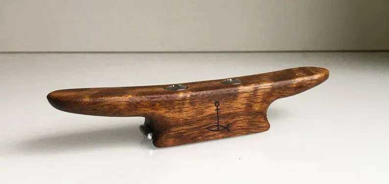 Slim oak boat cleat bottle opener lying on a linen cloth